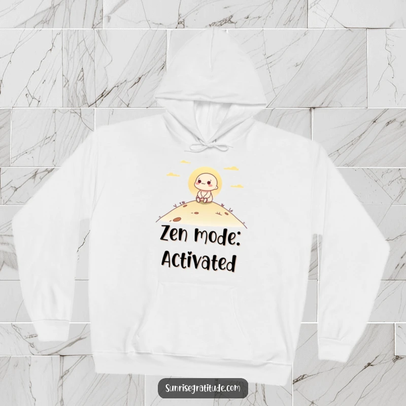 Funny hoodie showing a contented character sitting atop a hill, watching the tranquil dawn break over the landscape.