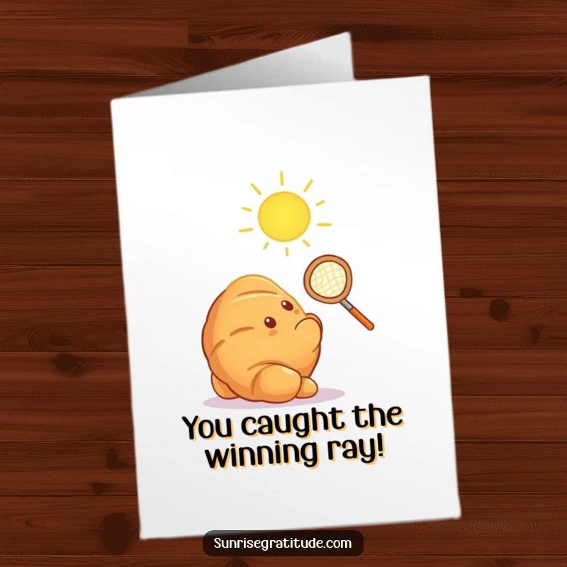 Funny Free Printable Congrats Card: A glowing croissant aims a tiny net at the first sun ray, celebrating a bright future.